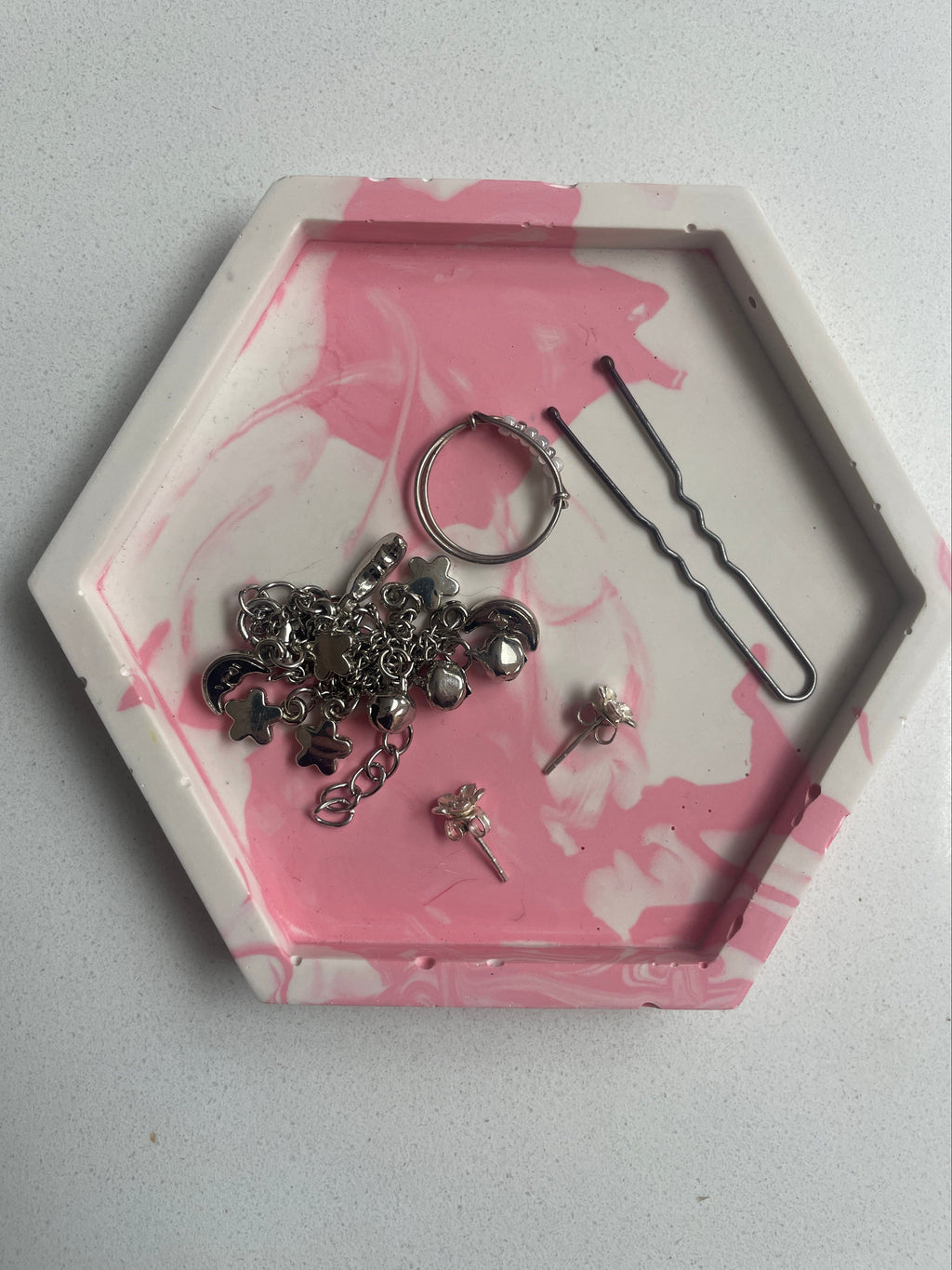 Marbled trinket tray with jewellery in.