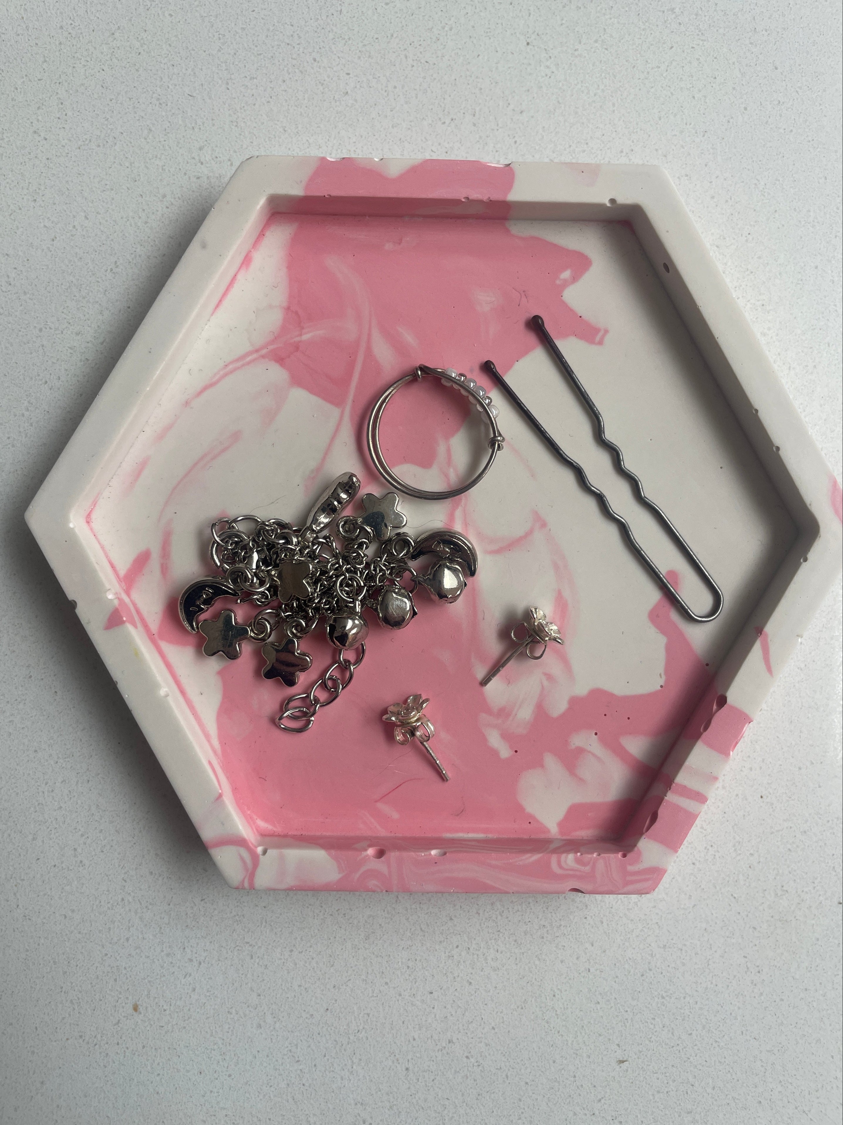 Marbled trinket tray with jewellery in.